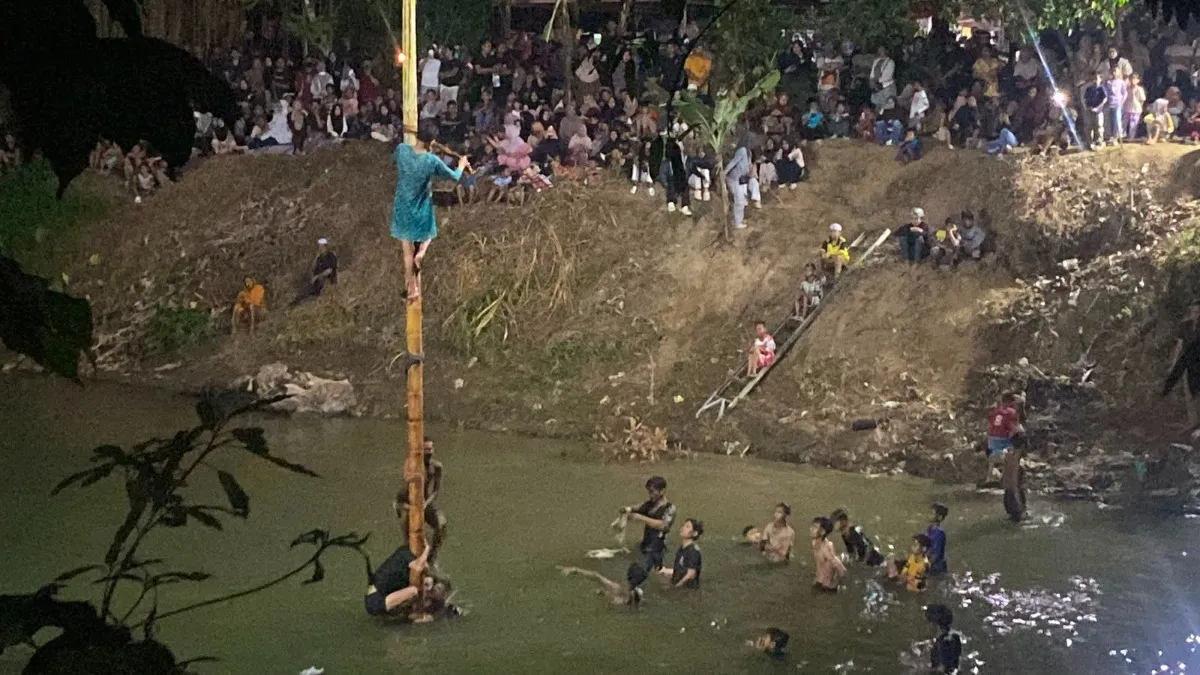13 Anak Muda Saling Bertumpu Rebut Hadiah Panjat Pinang di Tengah Sungai Aluan Bakti HST