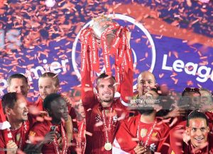 Jordan Henderson dari Liverpool memegang Trofi Liga Premier bersama Mohamed Salah merayakan kemenangan atas Chelsea FC di Anfield pada 22 Juli 2020. (getty images)