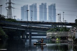 Pekerja membersihkan sampah dari genangan air yang terperangkap di lokasi dataran rendah dari pembuangan ke laut di lingkungan Pejagalan pada tanggal 1 September 2019 di Jakarta, Indonesia. (Foto oleh Ed Wray / Getty Images)