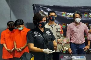 Seorang petugas kepolisian Polsek Metro Cilandak menunjukkan barang bukti pencurian yang dilakukan dua tersangka sepasang asisten rumah tangga (ART) di rumah aktor Jeremy Thomas, Selasa (29/12/2020). (ANTARA/Laily Rahmawaty/aa).