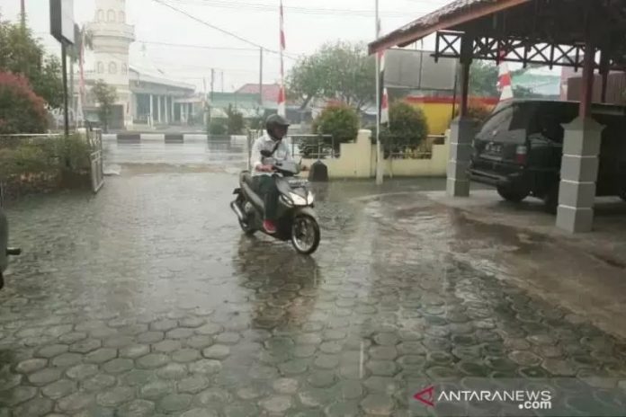 Ilustrasi - Salah satu warga berkendara saat hujan mengguyur wilayah Kota Palangka Raya, Rabu (14/8/2019). ANTARA/Rendhik Andika