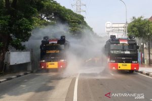 Kendaraan milik Satbrimob Polda Metro Jaya mendisinfeksi Jalan Jenderal Sudirman mencegah penyebaran COVID-19 di Ibu Kota mengawali 2021. (ANTARA/HO/Dokumentasi Satbrimob Polda Metro Jaya)