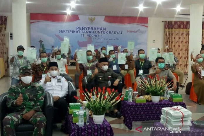 Bupati HSU H Abdul Wahid HK dan Ketua DPRD HSU Almien Ashar Safari bersama warga yang menerima Sertifikat Tanah Gratis di Mess Negara Dipa Amuntai, Selasa (5/1/21). (Antaranews Kalsel/Eddy Abdillah)