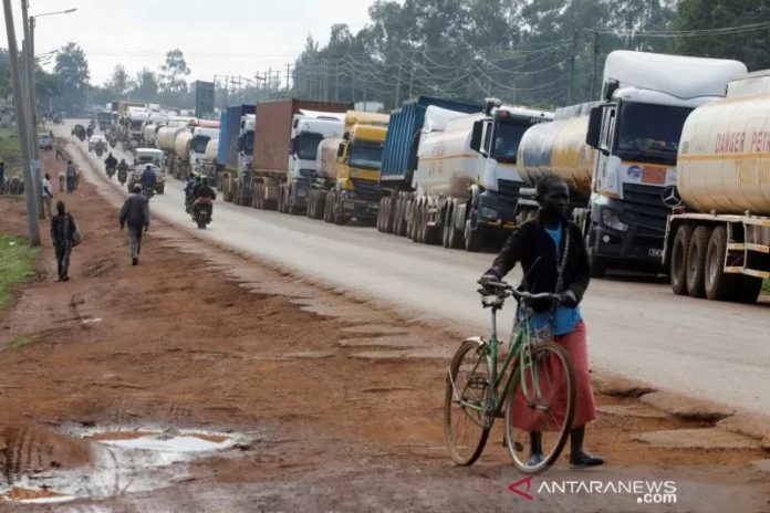 Seorang perempuan berjalan melewati truk-truk yang menunggu dalam antrian 10 kilometer untuk menyebrangi perbatasan Kenya-Uganda di kota Busia, Kenya, Sabtu (14/11/2020). Foto diambil tanggal 14 November 2020. REUTERS/Baz Ratner/hp/cfo (REUTERS/BAZ RATNER)