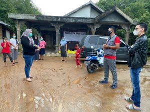 Hj Mariana menyarahkan bantuan nasi bungkus di Posko Desa Bingkulu, Kurau, yang terdampak banjir. (ist-wartabanjar.com)