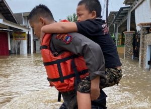 _Anggota polisi mengevakuasi seorang anak di Martapura Timur yang terdampak banjir. (istimewa via wartabanjar.com