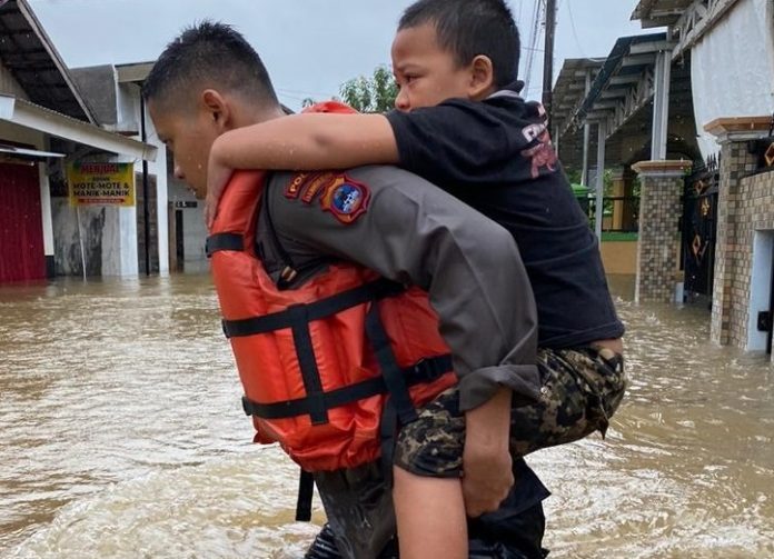 _Anggota polisi mengevakuasi seorang anak di Martapura Timur yang terdampak banjir. (istimewa via wartabanjar.com