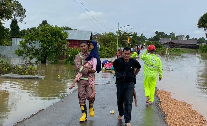 Anggota polisi mengevakuasi seorang anak di Martapura Timur yang terdampak banjir. (istimewa via wartabanjar.com)