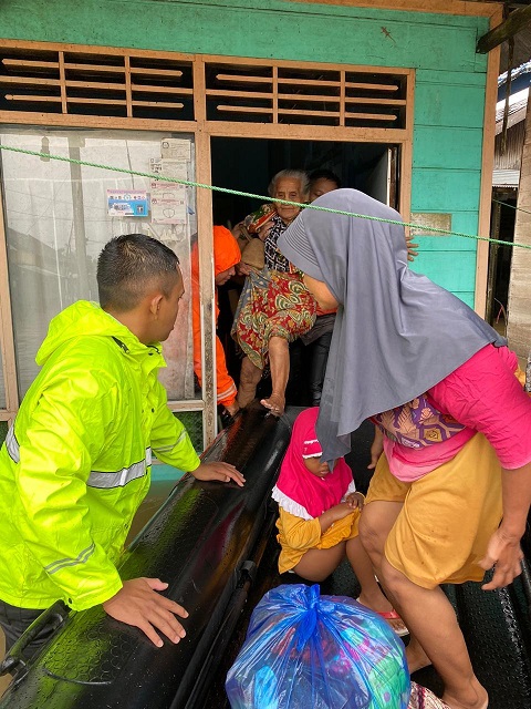 Anggota polisi mengevakuasi seorang nenek di Martapura Timur yang terdampak banjir. (istimewa via wartabanjar.com)