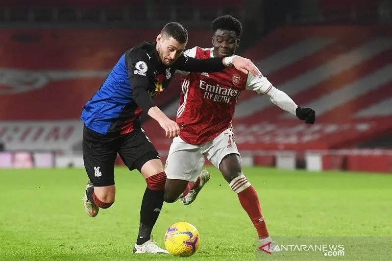 Bek Crystal Palace Joel Ward (kiri) berebut penguasaan bola dengan pemain sayap Arsenal Bukayo Saka dalam lanjutan Liga Inggris di Stadion Emirates, London, Inggris, Kamis (14/1/2021) waktu setempat. (ANTARA/REUTERS/POOL/Neil Hall)