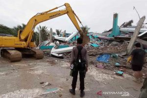 Petugas menggunakan alat berat memindahkan puing akibat gempa di Majene, Sulbar. (antara)