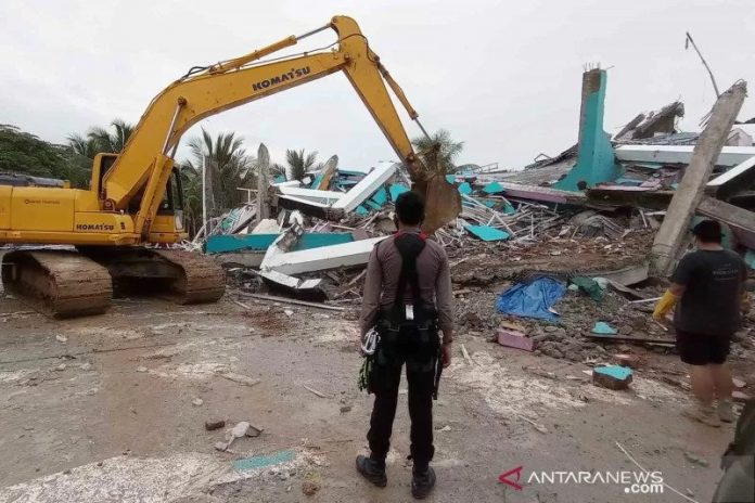 Petugas menggunakan alat berat memindahkan puing akibat gempa di Majene, Sulbar. (antara)