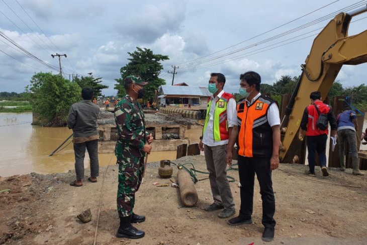 Dandim 1006/Mtp Letkol Arm Siswo Budiarto berkoordinasi dengan pelaksana pengerjaan jembatan darurat di Desa Benua Anyar Kecamatan Mataraman, Banjar, Kalsel yang putus dan ditarget selesai, Rabu malam ini. Foto istimewa