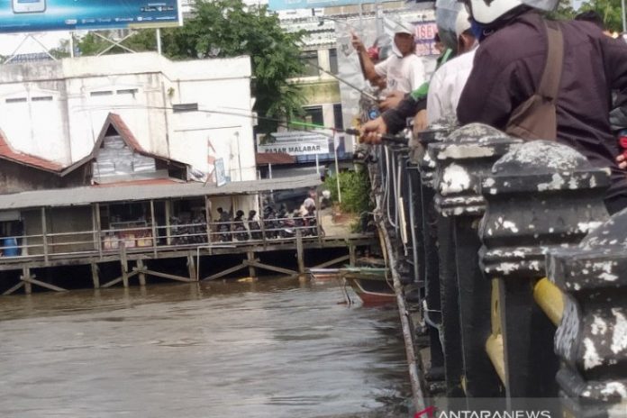 Para pemancing ramai memancing ikan lepas akibat banjir di sungai Martapura di atas jembatan Pangeran Antasari.(Antaranews Kalsel/Sukarli)