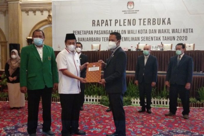 Ketua KPU Kota Banjarbaru Hegar Wahyu Hidayat menyerahkan surat keputusan penetapan pasangan Aditya Mufti Ariffin dan Wartono sebagai pasangan wali kota dan wakil wali kota terpilih kepada Wartono. Foto Yose Rizal/Antaranews Kalsel