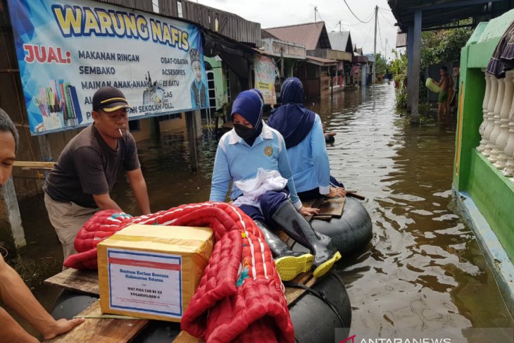 Ketua PIA Ardhya Garini Cabang 11 Daerah 2 Lanud Sjamsuddin Noor Banjarmasin, Ny Rosa Taufik Arsj, menembus banjir membawa bantuan untuk korban banjir. di Kabupaten Banjar. (antara)