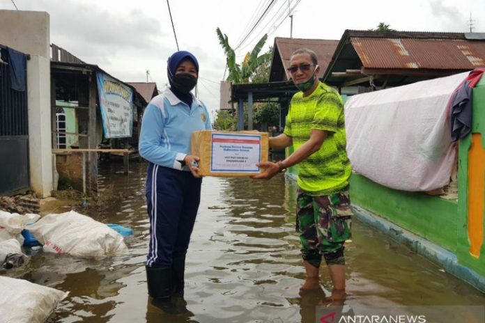 Ketua PIA Ardhya Garini Cabang 11 Daerah 2 Lanud Sjamsuddin Noor Banjarmasin, Ny Rosa Taufik Arsj, menyerahkan bantuan kepada korban banjir. (antara)