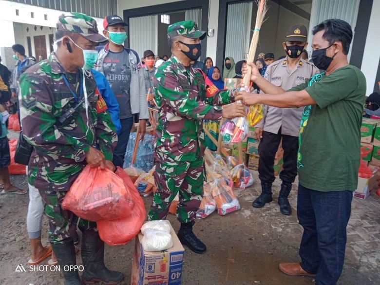 Danramil Gambut menyerahkan bantuan kepada pengungsi yang akan dipulangkan. (istimewa)