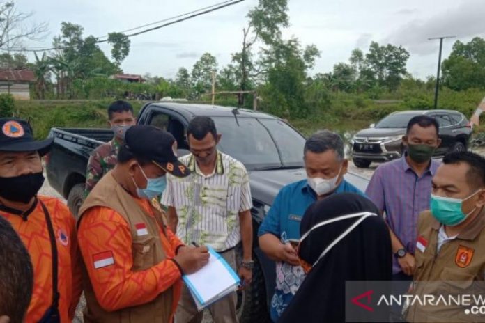 Kepala Pelaksana Harian BPBD Kota Banjarbaru Zaini Syahranie (kanan pakai masker hijau) bersama Camat Liang Anggang Rifai dan petugas BPBD mendata kerusakan rumah, bengkel dan warung akibat terkena puting beliung di Jalan Trikora Kelurahan Landasan Ulin Tengah Kecamatan Liang Anggang. Foto istimewa