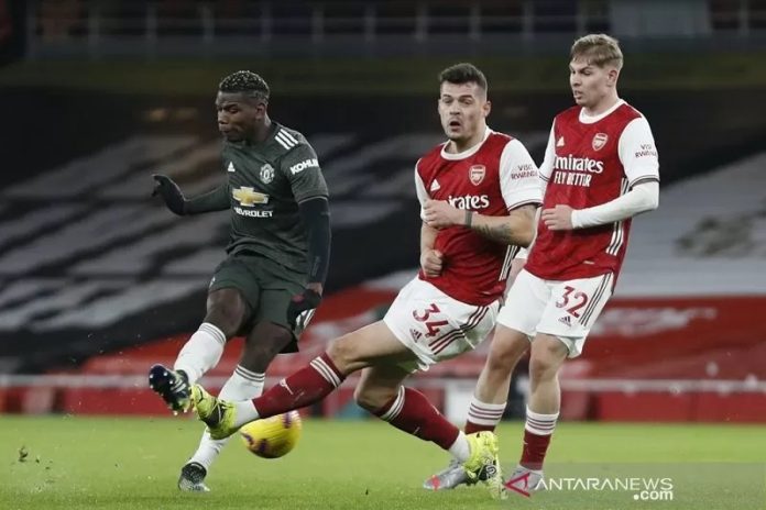 Gelandang Arsenal, Granit Xhaka (tengah) menghalau tembakan pemain Manchester United., Paul Pogba. (reuters via antara)