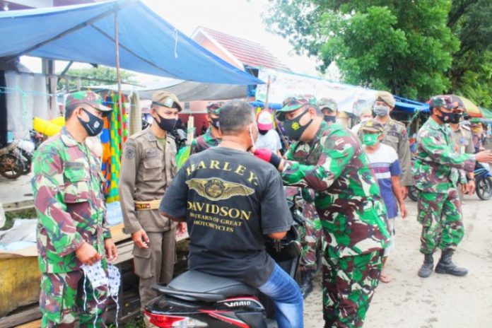 Petugas Gabungan Kabupaten Tabalong memeriksa masker seorang pengendara yang melintas. (antara)