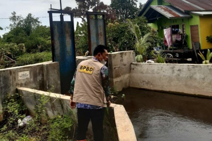 Plt Kepala BPBD Kota Banjarmasin Rudian Noor saat memantau kondisi air di bendungan Simpang Limau Ujung Banjarmasin Timur.(Antaranews Kalsel/Sukarli)