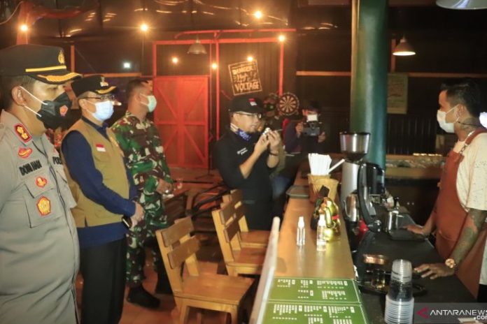 Walikota Banjarbaru, Darmawan Jaya Setiawan (pakai rompi) saat mendatangi sebuah warung untuk memastikan penerapan PPKM. (antara)