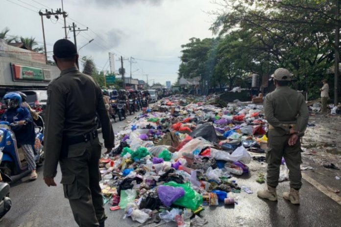 Dua petugas Satpol-PP Kota Banjarmasin saat melaksanakan operasi yustisi terhadap pelanggar pembuang sampah.(Antaranews Kalsel/istimewa)