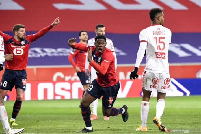 Reaksi pemain Lille Jonathan David saat menilai ada pemain Brest menyentuh bola dengan tangan kala keduanya bertemu dalam laga pekan ke-25 Liga Prancis di Stadion Pierre-Mauroy, Minggu (14/2/2021). (ANTARA/FEP/Panoramic/Anthony Bibard via Reuters)