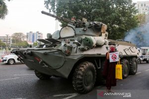 Seorang biksu Buddha yang memegang tanda berdiri di samping kendaraan lapis baja saat protes terhadap kudeta militer, di Yangon, Myanmar, Minggu (14/2/2021). ANTARA FOTO/REUTERS / Stringer/aww.