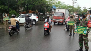 Anggota TNI dan Satpol PP Banjarmasin menyampaikan imbauan disiplin protokol kepada warga di Jalan KS Tubun. (IG @Kodim 1007 Banjarmasin)