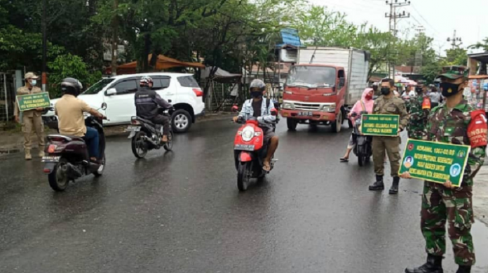 Anggota TNI dan Satpol PP Banjarmasin menyampaikan imbauan disiplin protokol kepada warga di Jalan KS Tubun. (IG @Kodim 1007 Banjarmasin)