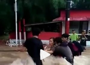 Para pemuda tolong ibu gendong anak dalam banjir di Ciledug. (IG @tangerang24jam)