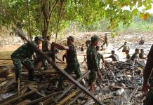 Anggota TNI di HST Bersama Relawan Bersihkan Sampah Pasca Banjir dan Longsor
