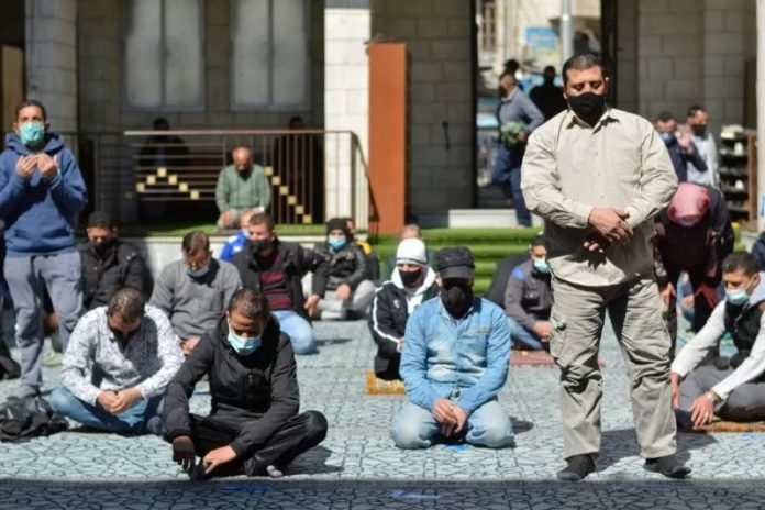 Warga Yordani memakai masker saat shalat Jumat di Masjid al-Husseini dengan penjagaan ketat terkait pandemi Covid-19. (antara)