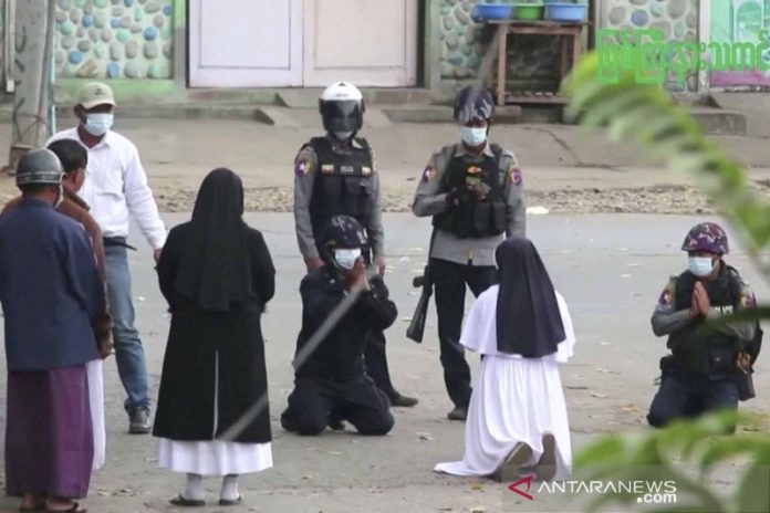 Seorang biarawati Suster Ann Rose Nu Tawng (kedua kanan) berlutut di depan aparat kepolisian untuk memohon agar menahan diri dari kekerasan terhadap anak-anak dan penduduk di tengah unjuk rasa anti kudeta militer di Myitkyina, Myanmar, Senin (8/3/2021) seperti terlihat di dalam foto yang diambil dari potongan video. ANTARA FOTO/MYITKYINA NEWS JOURNAL/Handout via REUTERS/wsj.