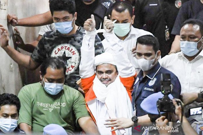 Habib Rizieq Shihab (tengah) berjalan menuju mobil tahanan usai diperiksa di Mapolda Metro Jaya, Jakarta, Minggu (13/12/2020) dini hari. Rizieq Shihab ditahan penyidik Ditreskrimum Polda Metro Jaya untuk kepentingan penyidikan perkara kasus dugaan pelanggaran protokol kesehatan COVID-19 terkait kerumunan di Petamburan, Tanah Abang, Jakarta pada 14 November lalu. ANTARA FOTO/Hafidz Mubarak A/pras.