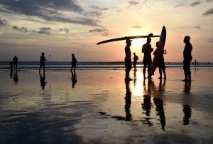 Peselancar Bali memegang sufboards mereka saat matahari terbenam di pantai Kuta dekat Denpasar, di pulau resor Bali di Indonesia pada 13 Mei 2017. / AFP PHOTO / SONNY TUMBELAKA (Kredit foto harus dibaca SONNY TUMBELAKA / AFP via Getty Images)