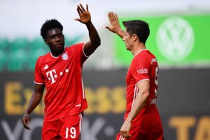 Robert Lewandowski dari Muenchen merayakan gol ketiga timnya bersama rekan setimnya Alphonso Davies selama pertandingan Bundesliga antara VfL Wolfsburg melawan FC Bayern Muenchen di Volkswagen Arena pada 27 Juni 2020 di Wolfsburg, Jerman. (Foto oleh Stuart Franklin / Getty Images)
