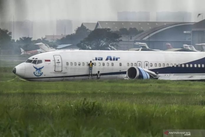 Sejumlah petugas melakukan evakuasi terhadap pesawat kargo Trigana Air PK-YSF dengan rute Halim Perdanakusuma - Makassar keluar dari runway (landasan pacu) di Bandara Halim Perdanakusuma, Jakarta Timur, Sabtu (20/3/2021). ANTARA FOTO/M Risyal Hidayat/foc.