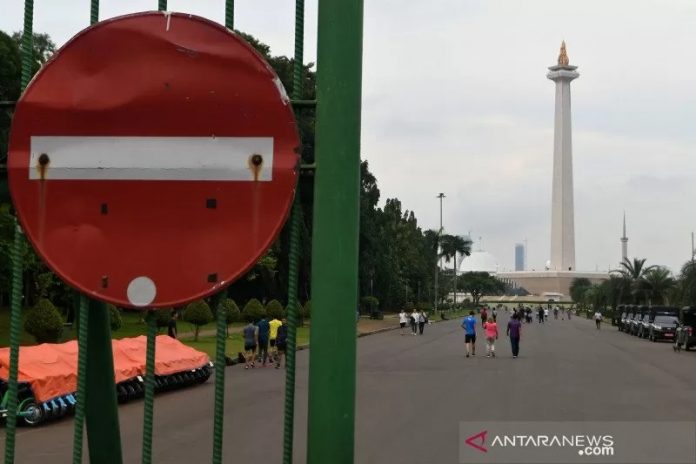 Sejumlah warga berjalan di kawasan Monumen Nasional, Jakarta, Rabu (11/3/2020). Gubernur DKI Jakarta Anies Baswedan mengeluarkan arahan yang diterima Organizing Committee (OC) Formula E Jakarta bahwa penyelenggaraan Jakarta E-Prix yang sedianya diadakan pada 6 Juni 2020 ditunda hingga waktu yang belum ditentukan sebagai antisipasi penyebaran wabah virus Corona (COVID-19) di Indonesia, khususnya Jakarta. ANTARA FOTO/Aditya Pradana Putra/aww.