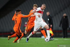 Penyerang Turki Burak Yilmaz (kanan) berusaha melepaskan diri dari bek Belanda Owen Wijndal (kiri) dalam pertandingan Kualifikasi Piala Dunia 2022 Grup G di the Ataturk Olympic Stadium, Istanbul, Turki pada 25 Maret 2021. (AFP/TOLGA BOZOGLU)