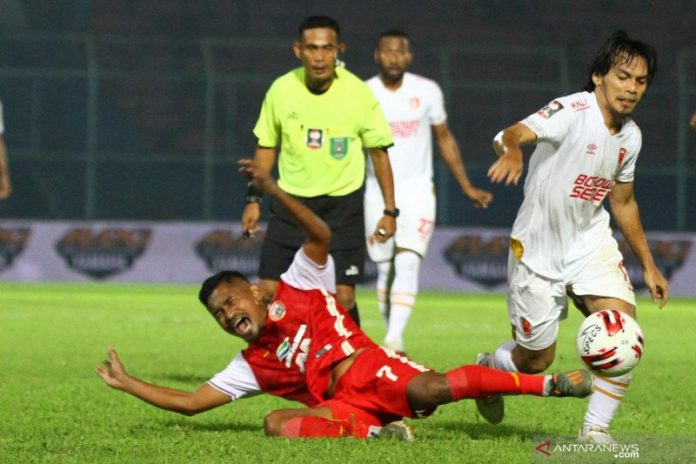 Pesepakbola PSM Makassar, Rasyid Bakri (kanan) melewati pesepakbola Persija Jakarta, Ramdani Lestaluhu (kiri) yang terjatuh dalam pertandingan babak penyisihan Grup B Piala Menpora di Stadion Kanjuruhan, Malang, Jawa Timur, Senin (22/3/2021). PSM Makassar mengungguli Persija Jakarta dengan skor akhir 2-0. ANTARA FOTO/Ari Bowo Sucipto (ARI BOWO SUCIPTO/ARI BOWO SUCIPTO)