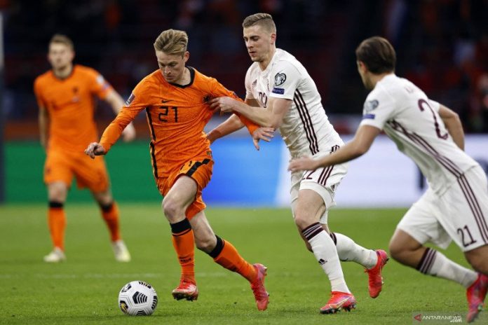 Gelandang Belanda Frenkie de Jong (kiri) berusaha mempertahankan bola dari pemain Latvia Vladislavs Gutkovskis dalam pertandingan Kualifikasi Piala Dunia 2022 Grup G di Johan Cruyff Arena Stadium, Amsterdam pada 28 Maret 2021. (AFP/MAURICE VAN STEEN)