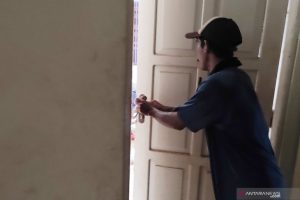 Petugas menunjukan pintu gudang logistik di Stadion Murakata, Barabai, yang dijebol dan dirusak. (antara)