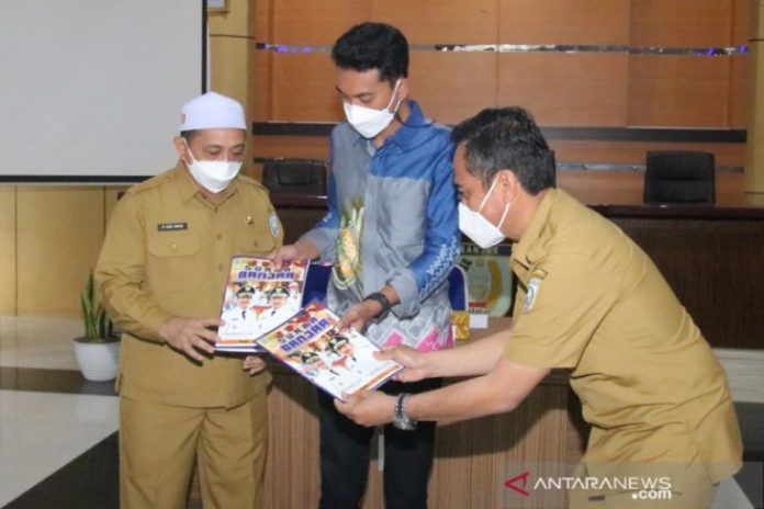 Kepala Dinas Komunikasi, Informatika, Statistik dan Persandian Banjar M Aidil Bastih (paling kanan) menyerahkan majalah Suara Banjar kepada Bupati Banjar Saidi Mansyur disaksikan Wakil Bupati Banjar Said Idrus Al-Habsyie. Foto Diskominfostandi Banjar/Antaranews Kalsel