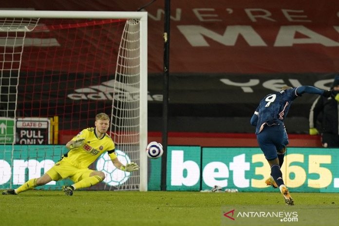 Penyerang Arsenal Alexandre Lacazette (kanan) menaklukkan kiper Sheffield United Aaron Ramsdale untuk mencetak gol keduanya dalam lanjutan Liga Inggris di Stadion Bramall Lane, Sheffield, Inggris, Minggu (11/4/2021) waktu setempat. (ANTARA/REUTERS/POOL/Tim Keeton)