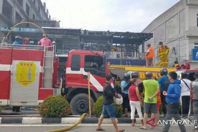 Petugas pemadam kebakaran saat melakukan evakuasi terhadap korban pada musibah kebakaran yang terjadi di Jalan Pangeran Diponegoro, Kelurahan Pasiran, Kecamatan Singkawang Barat terbakar, Senin (12/4) pagi. ANTARA/Rudi