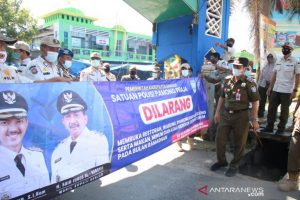 Pelaksana Tugas Kasatpol PP Banjar Aidil Basith memantau anggotanya memasang spanduk maupun baliho yang berisi peringatan dan imbauan tentang peraturan daerah Ramadhan 1442 Hijriah di kabupaten setempat. Foto Diskominfo Banjar/Antaranews Kalsel