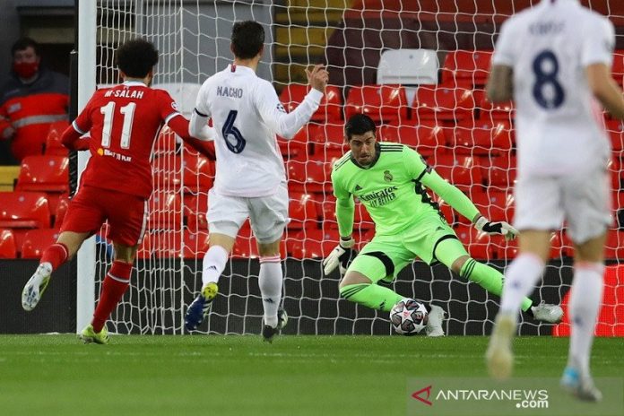 Kiper Real Madrid Thibaut Courtois (kanan) melakukan penyelamatan gemilang menghalau bola tembakan penyerang Liverpool Mohamed Salah dalam leg kedua perempat final Liga Champions di Stadion Anfield, liverpool, Inggris, Rabu (14/4/2021) waktu setempat. (ANTARA/REUTERS/David Klein)